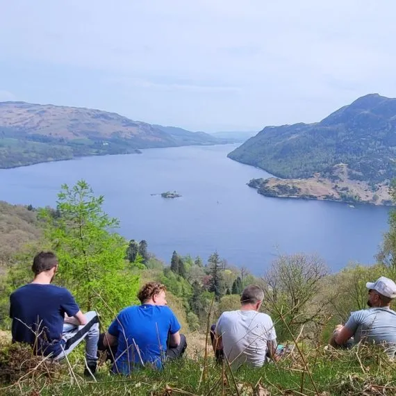 Men sitting looking over a lake in the Lake District