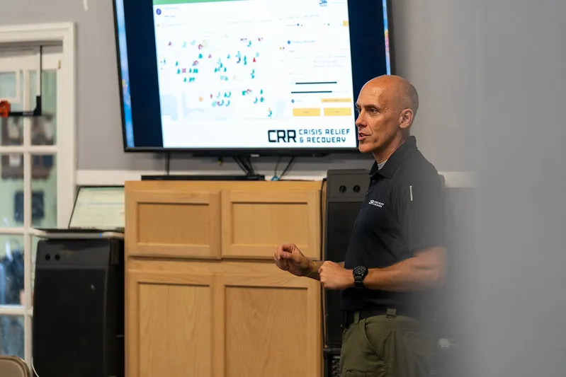 man teaching in front of tv screen