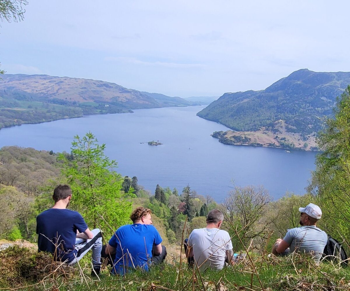 Men sitting looking over a lake in the Lake District